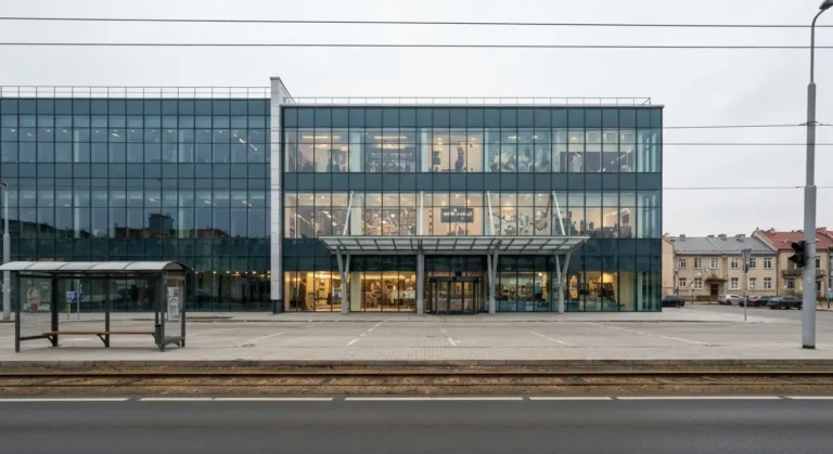 Nowoczesne centrum handlowe przy ulicy Jagiellonskiej w Bydgoszczy - szklana fasada, wejscie glowne i parking, w tle tor